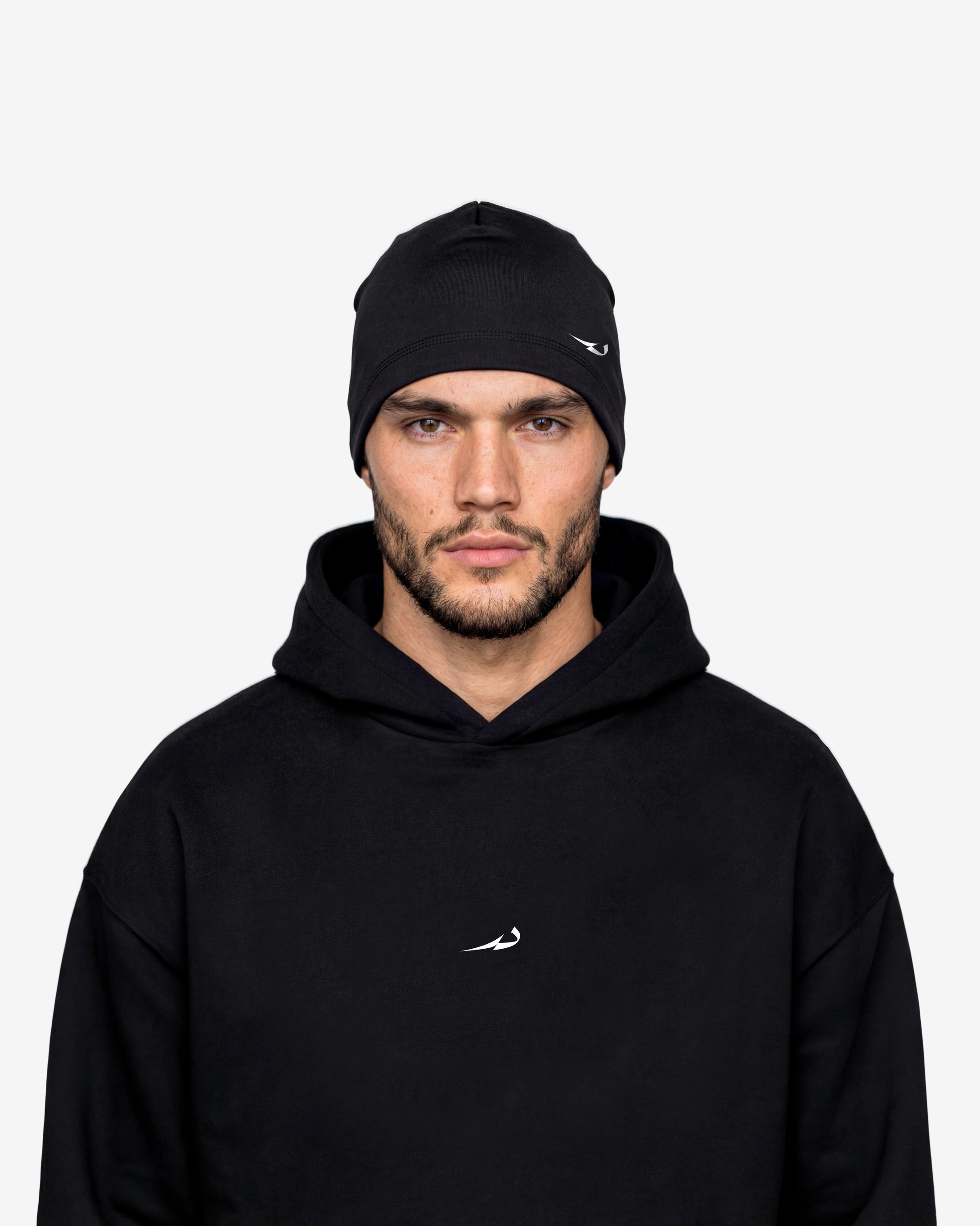 Man wearing a black hoodie and beanie with a logo on a white background