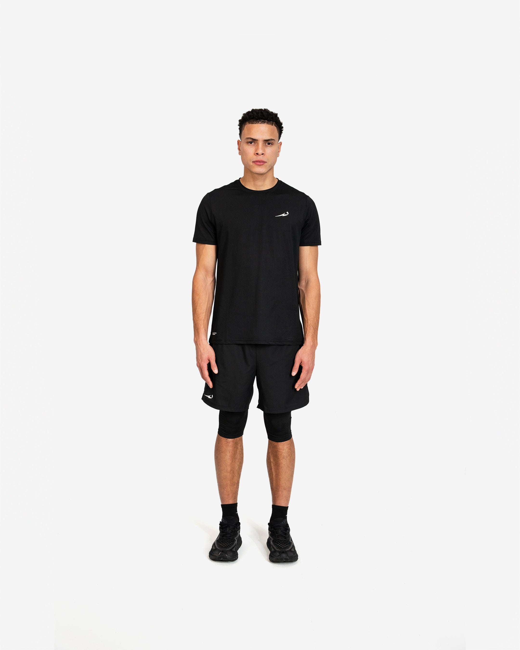 Person wearing a black athletic outfit with a deenathletic logo on a white background