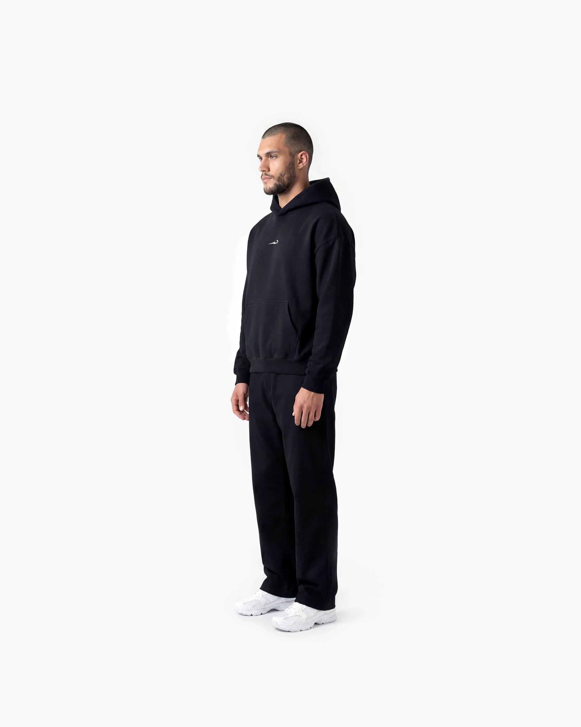 Man wearing a black Deenathletic hoodie on a white background