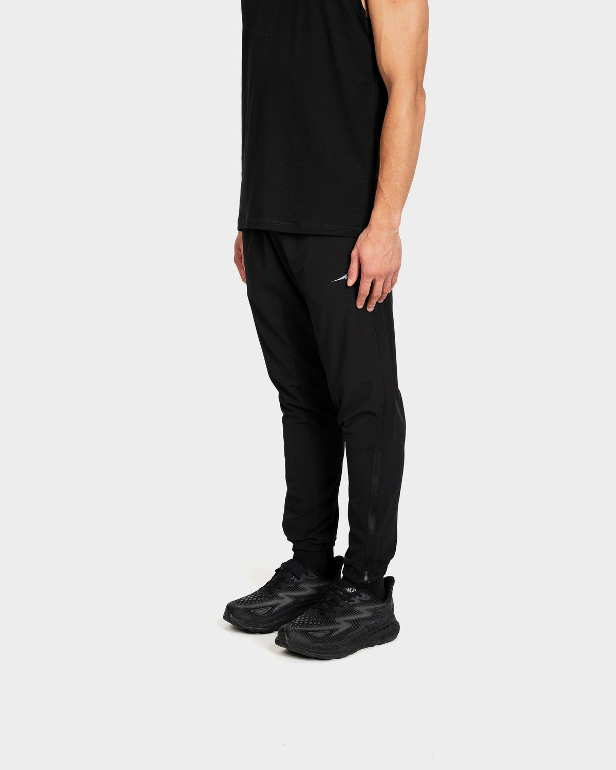 Person wearing black Deenathletic pants and shoes on a white background
