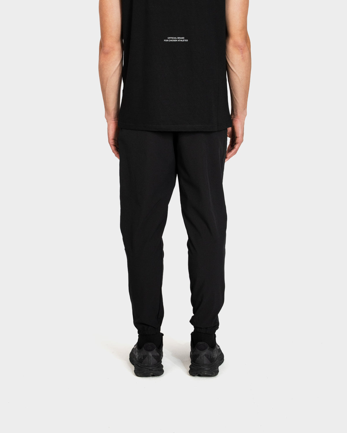 Person wearing black Deenathletic pants and shoes on a white background