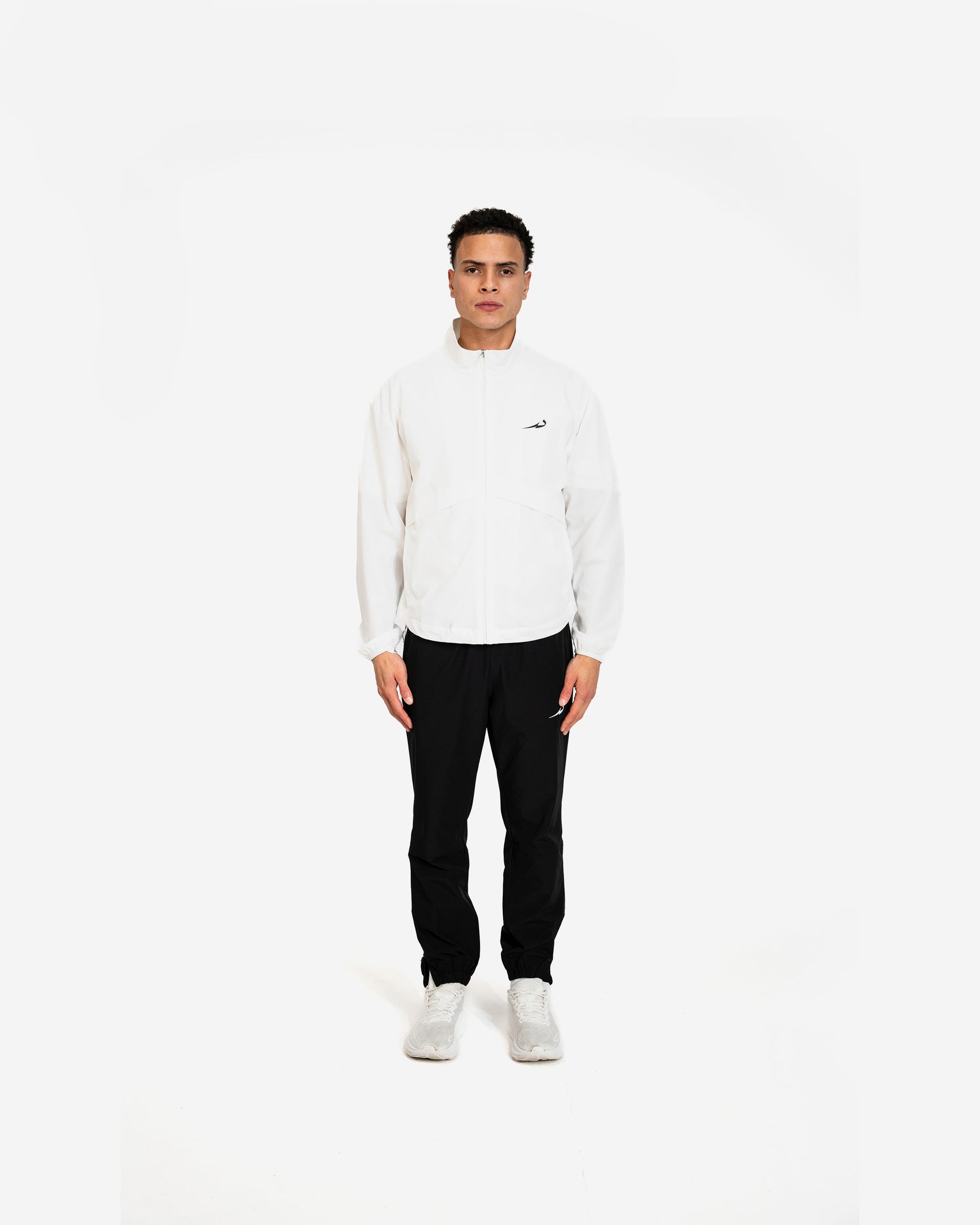 Person wearing a white sweater and black pants on a white background
