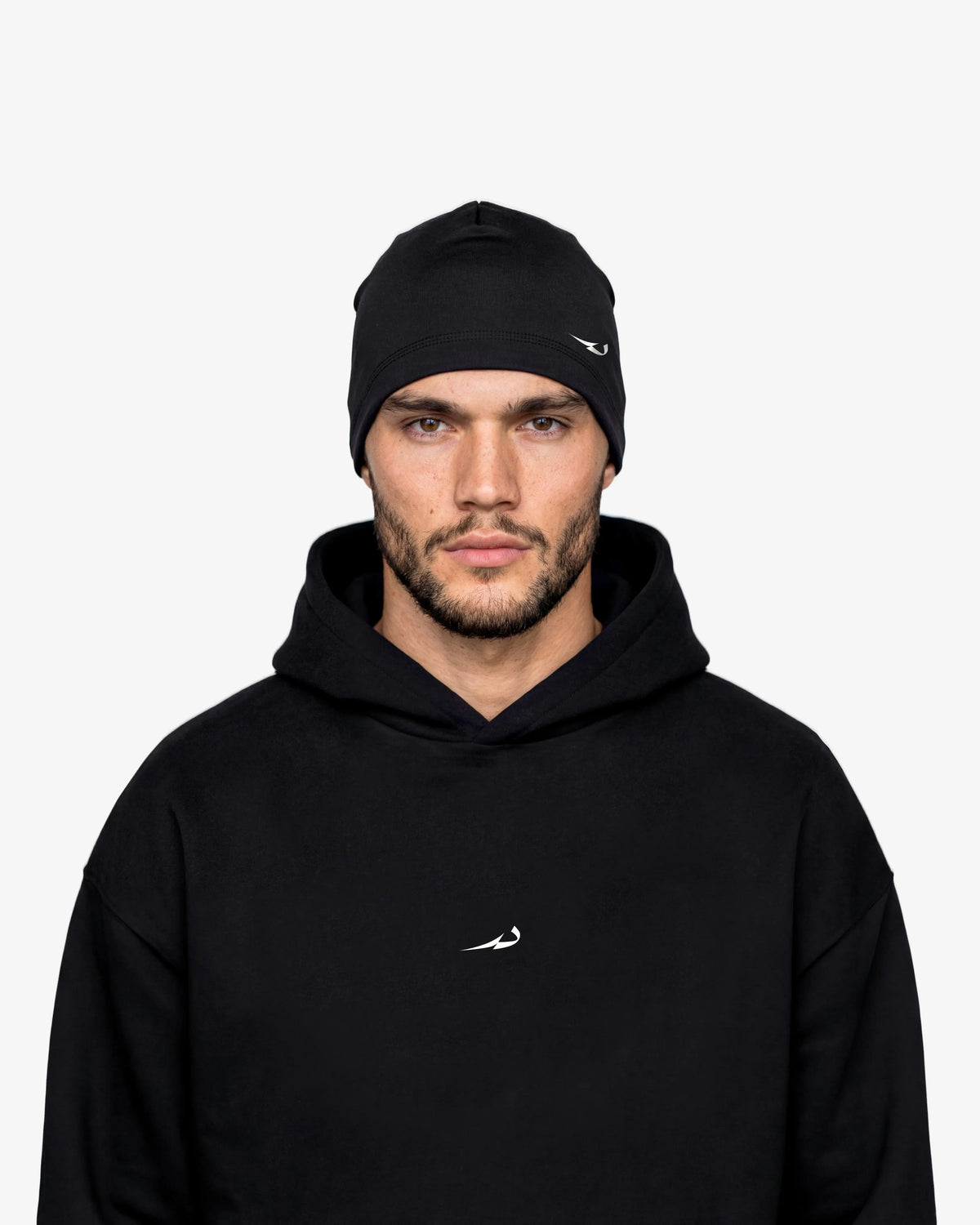 Man wearing a black hoodie and beanie with a logo on a white background
