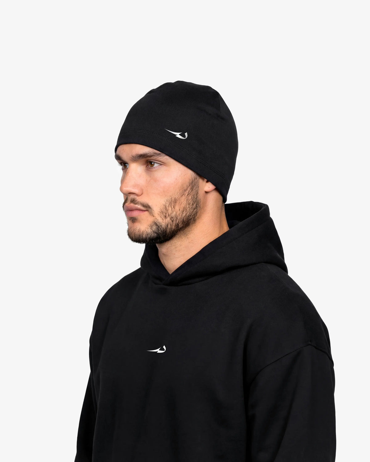 Man wearing a black beanie and hoodie with a logo on a white background